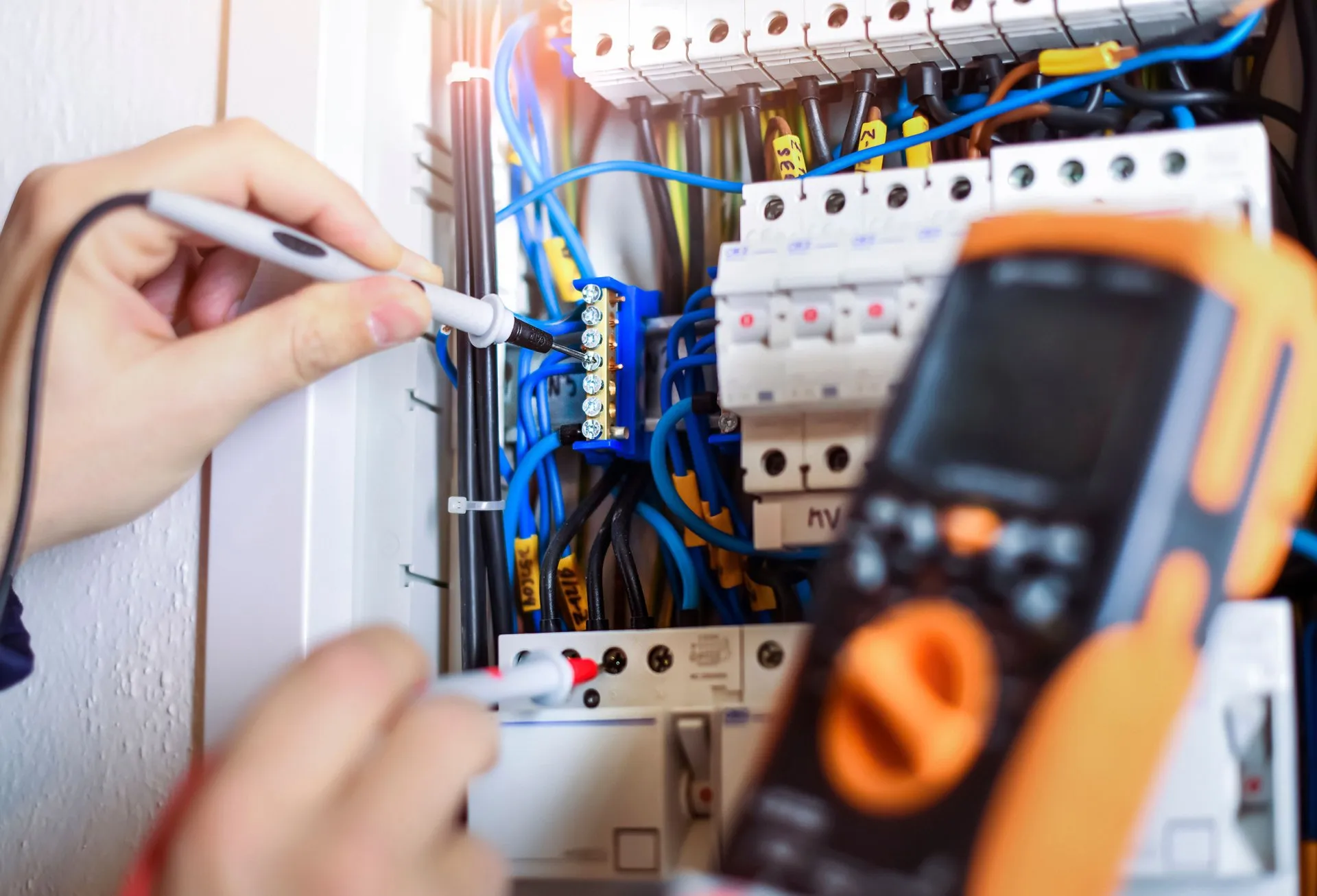 A person working on electrical equipment in an office.